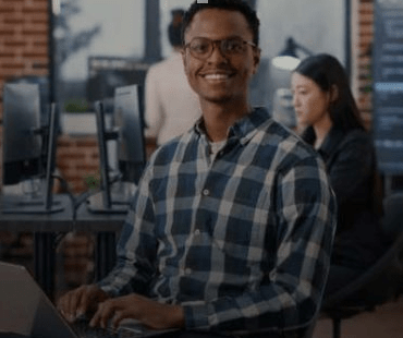Young black male engineer at work desk in lounge